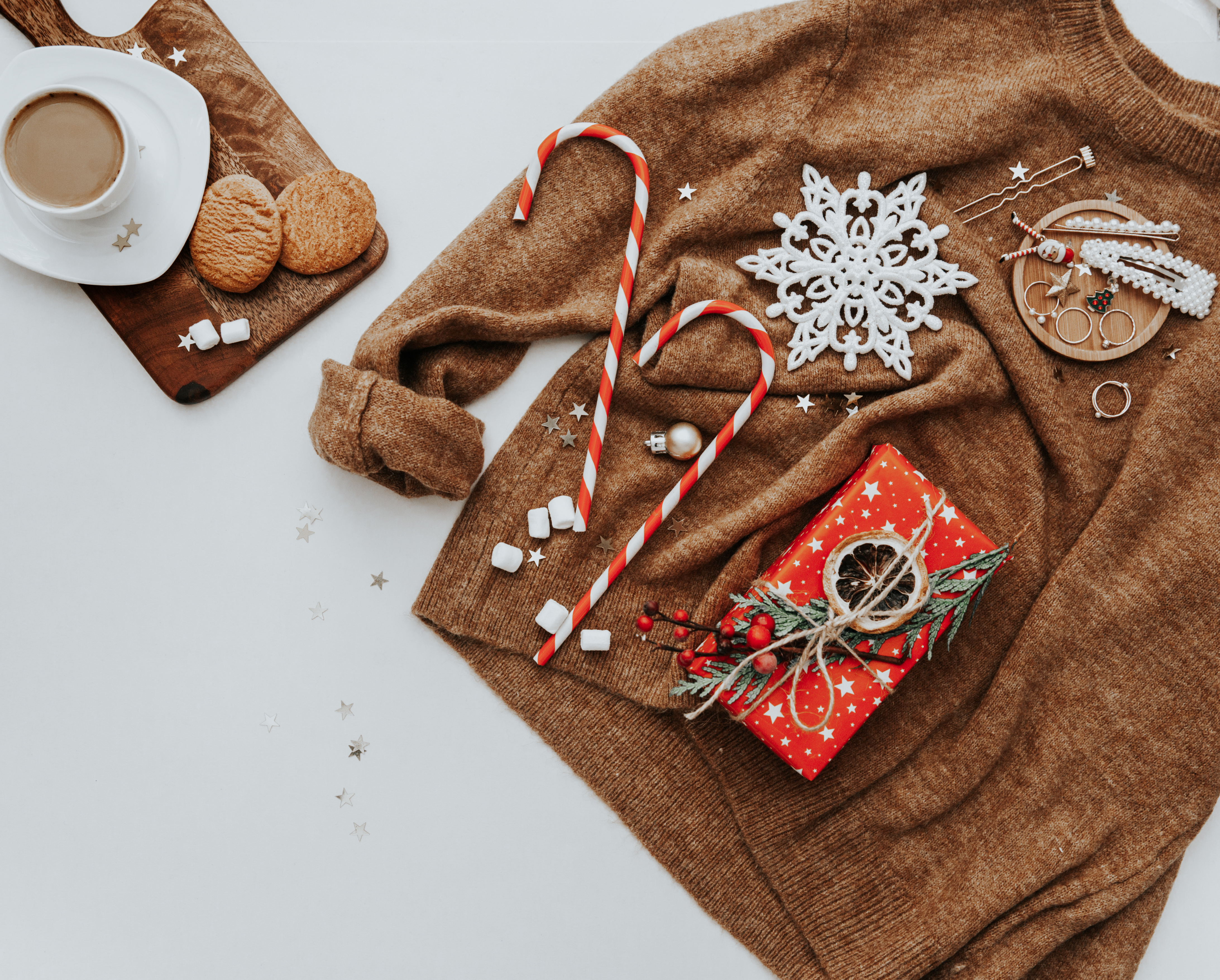 Christmas still life background. decorations, hot coffee, cookies, and camel color sweater. view from above. Cozy Winter Holidays